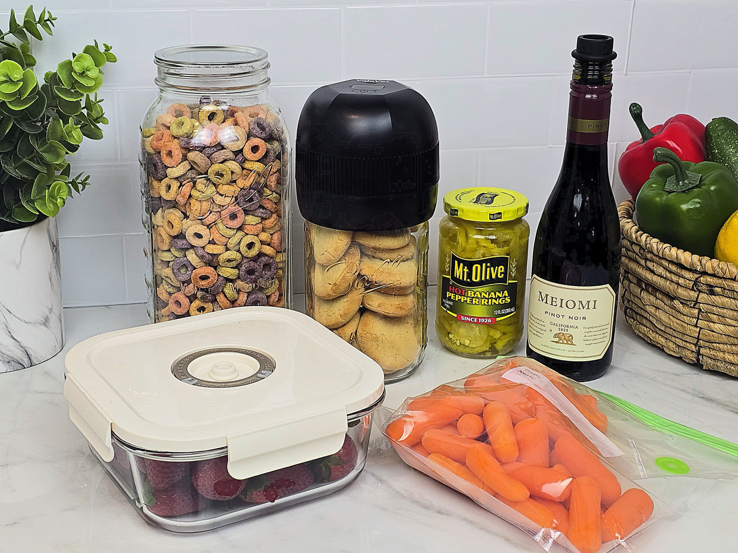 VidaVac vacuum sealer shown with jars, twist lid containers, vacuum seal bags, marinate container, and wine bottle — showcasing its multifunctional uses