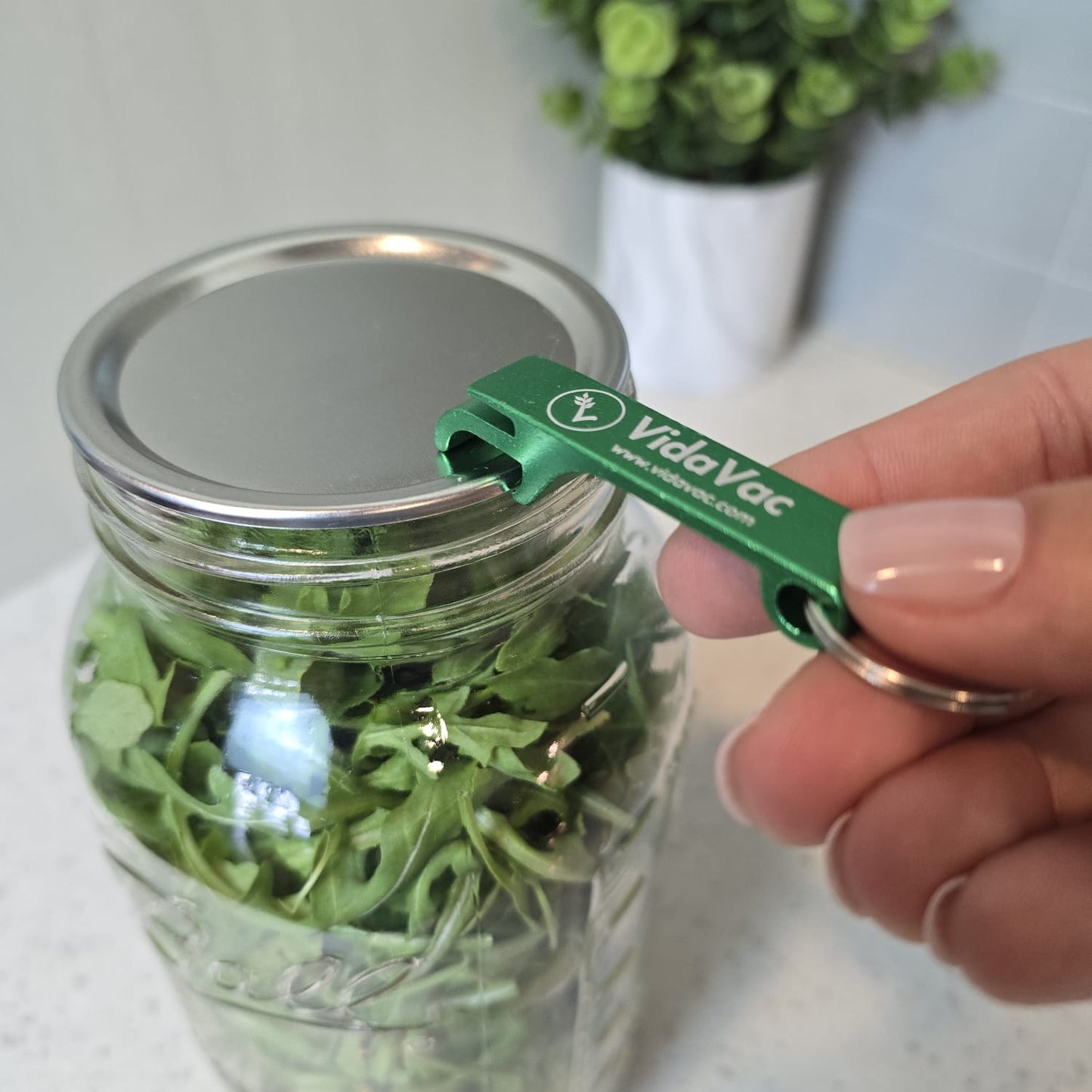 Using VidaVac keychain opener to break vacuum seal on twist lid jar